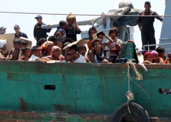 Thailand's navy tow a boat, carrying Rohingya refugees, away from Thai waters near the country's Koh Lipe island, in 2015 [File: Aubrey Belford/Reuters]