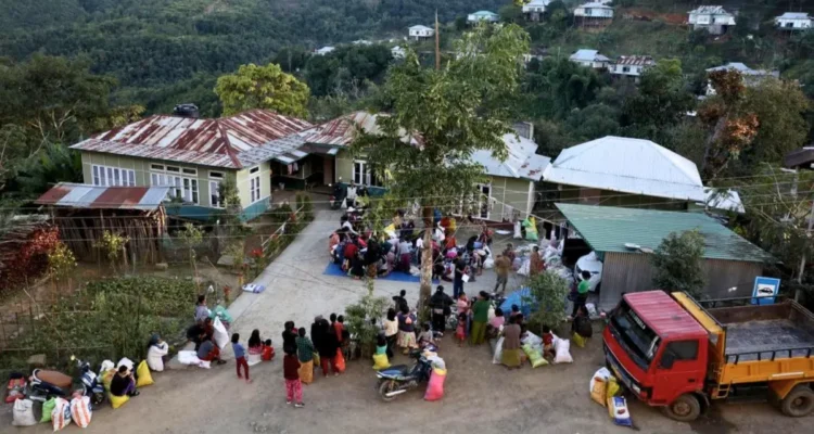 Displaced individuals from Myanmar gather at a temporary relief centre near the India-Myanmar border in Mizoram to collect donated clothing amid ongoing unrest and cross-border displacement.